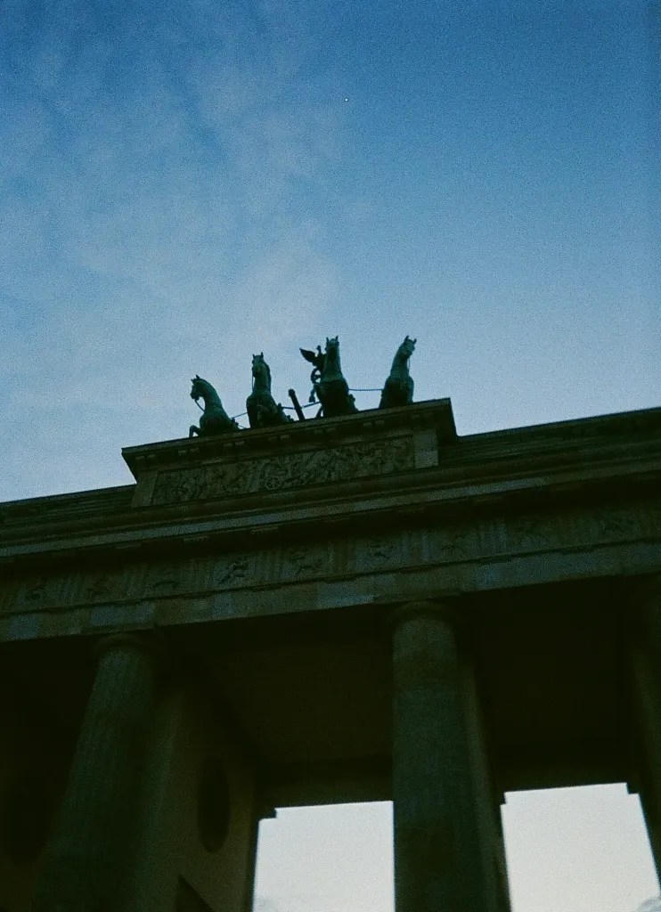 Brandenburg gate, the top of the arch with 4 prancing horses and concrete pillars.