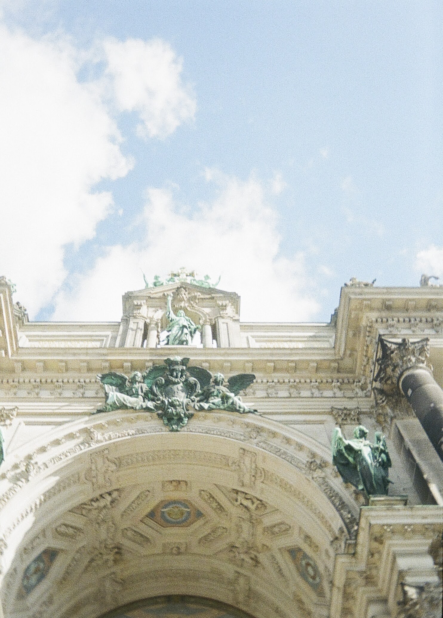 A feature of architecture in Berlin, featuring an arch with blue figures and ornate engravings.